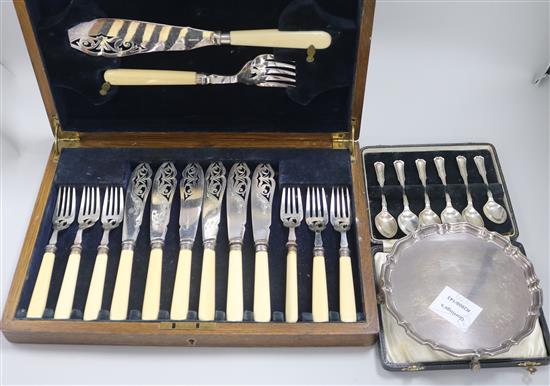 A George V silver waiter, a cased set of six silver spoons and a cased set of plated fish eaters including servers.